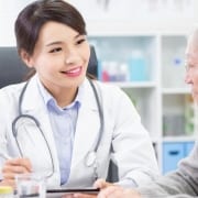 An elderly woman discussing changing Medicare doctors with a medical professional
