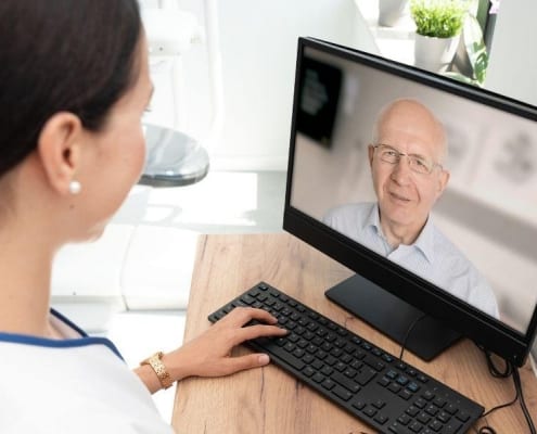 A healthcare professional providing telehealth services to a senior patient