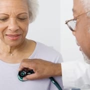 A doctor who accepts Medicare Advantage plans checking the heartbeat of a senior woman