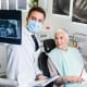 A dentist reviewing x-rays of a patient who is switching dentist offices to a senior dental center