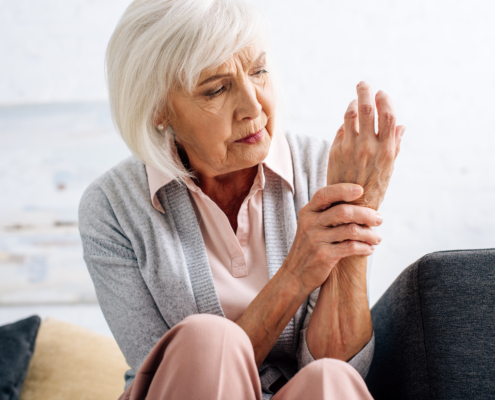 Photo of senior woman with arthritis pain holding her wrist