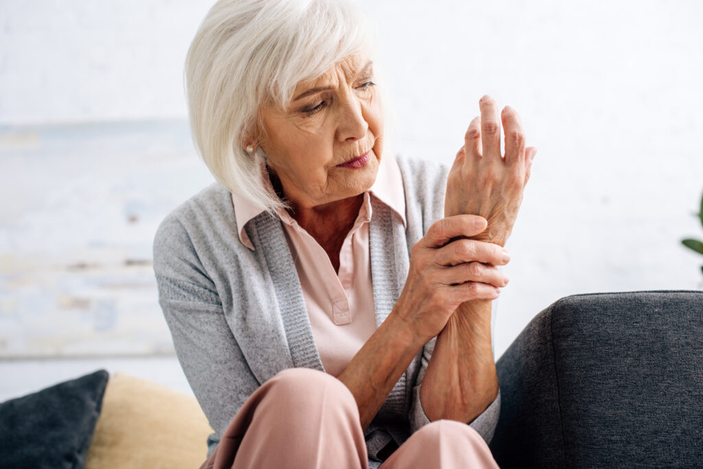 Photo of senior woman with arthritis pain holding her wrist